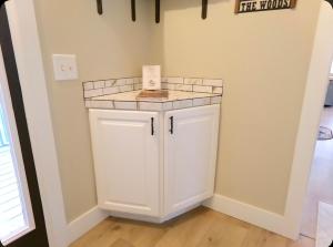 a small white cabinet in a corner of a room at Cookie's Cottage in Caseville +40 photos