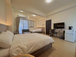 a bedroom with a bed and a desk and a television at 星爍民宿 in Ch'ih-k'an-lou