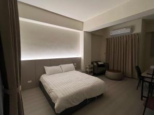 a bedroom with a white bed and a window at 星爍民宿 in Ch'ih-k'an-lou