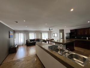 a kitchen and living room with a sink and a couch at 37 On Anderson in Pretoria