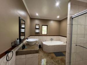 a bathroom with a tub and a sink and a bath tub at 37 On Anderson in Pretoria +65 photos