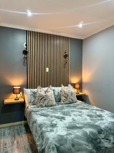 ein Schlafzimmer mit einem großen Bett und zwei Lampen in der Unterkunft Cingar Suites in East London