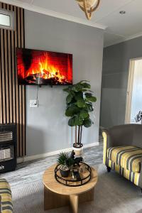 ein Wohnzimmer mit einem Kamin in der Wand in der Unterkunft Cingar Suites in East London