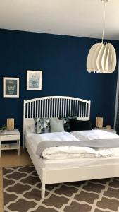 a bedroom with a white bed and a blue wall at Römerburg Apartments Burgstraße in Boppard