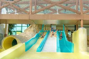 a group of kids playing on a water slide at Camping Le Parc de Paris in Villevaudé