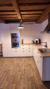 a kitchen with white cabinets and a stove top oven at Bukovská chaloupka in Bernartice +16 photos