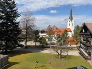 a church and a yard with a swing at Gasthof Rössle in Sulzberg