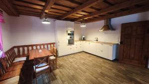 a kitchen with a wooden table and a wooden floor at Bukovská chaloupka in Bernartice