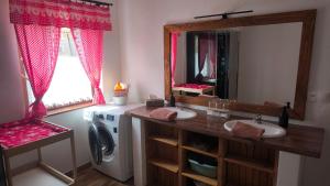 a bathroom with a sink and a washing machine at Bukovská chaloupka in Bernartice