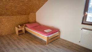 a small bedroom with a bed and a table at Bukovská chaloupka in Bernartice
