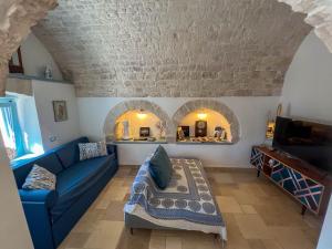 a living room with a blue couch and two arches at Trullo Dimora Podere Papilio in Noci