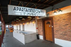a sign for a restaurant on the side of a building at Apartamentowiec Kuźniar in Kostrzyn nad Odrą