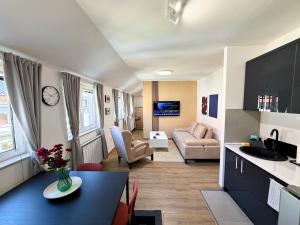 eine Küche und ein Wohnzimmer mit einem Tisch und einem Sofa in der Unterkunft Soni Trg in Tuzla