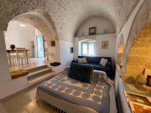 a living room with a bed and a couch at Trullo Dimora Podere Papilio in Noci +138 photos
