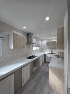 a kitchen with white cabinets and a stove top oven at Sugar Beach Villa Bangsaen in Ban Bang Saen (1)