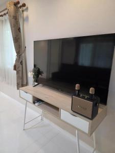 a large flat screen tv in a living room at Sugar Beach Villa Bangsaen in Ban Bang Saen (1)