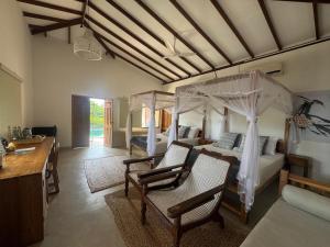 a room with a bedroom with a bed and chairs at C Beyond Nilaveli in Nilaveli