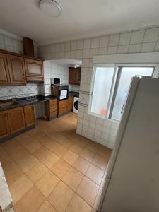 a kitchen with wooden cabinets and a large window at Apartament Mediteranean in Valencia