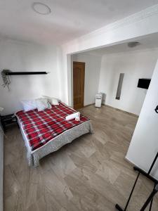 a bedroom with a bed with a plaid blanket at Apartament Mediteranean in Valencia