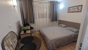 a small bedroom with a bed and two chairs at Pau'Ze in Idron