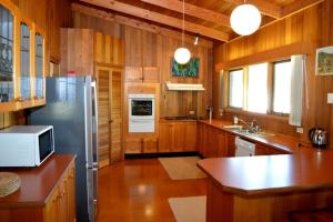 a kitchen with wooden cabinets and a stainless steel refrigerator at Lisieux in Metung +6 photos