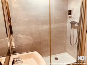 a shower with a glass door next to a sink at Angel de la Guarda 18 in Soria