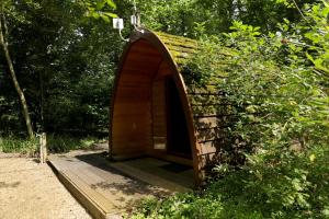 a small wooden tunnel in the middle of a forest at Camping Pod's in Hanworth