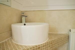 a bathroom with a white tub on a tiled wall at Camping Pod's in Hanworth +10 photos