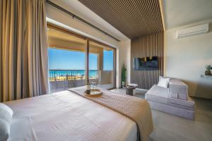 a bedroom with a large bed and a large window at Solmare beachfront apartments in Panormos Rethymno