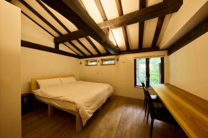 a bedroom with a bed and a desk and a window at YADO SEN -仙- Komatsu in Komatsu