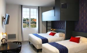 a hotel room with two beds and a table at Hôtel du Parc & Spa in Hossegor +49 photos