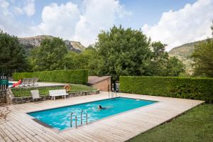 a person swimming in a swimming pool in a yard at Huttopia Barcelona Pirineos in Guardiola de Berguedà +27 photos