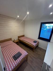 a room with two beds and a window at Apartmán ESKIMO in Bystrá