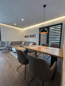 a dining room with a table and chairs and a couch at Apartmán ESKIMO in Bystrá