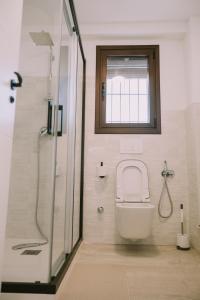 a bathroom with a toilet and a shower with a window at Casa Aula Minerva Sapientia 2 Habitaciones in Almedinilla +31 photos