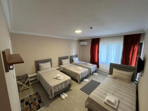 a hotel room with two beds and a couch at Efes Artemis Hotel in Selçuk