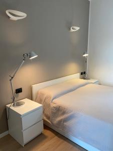 a bedroom with two beds and a desk with a lamp at Appartamento Laghetto in Segrate