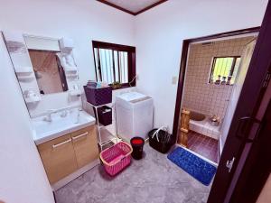 a bathroom with a sink and a toilet and a shower at 民泊 みづき 一棟貸し in Ibusuki +15 photos