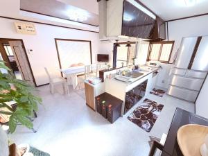 a kitchen with a sink and a table at 民泊 みづき 一棟貸し in Ibusuki