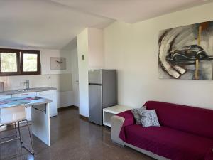 a living room with a purple couch and a kitchen at All You Need Holiday in Pula