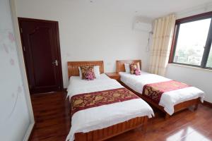 sypialnia z 2 łóżkami i oknem w obiekcie Tianmuhu Tianyuege Villa w mieście Liyang