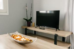 a living room with a television and a bowl of food at Meltemi Beach Apartments 2 in Milatos