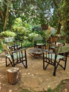 a group of chairs sitting around a fire pit at Karen Little Paradise, ECO Garden Hotel & Farm in Nairobi