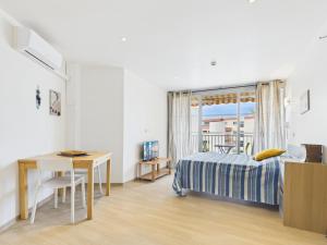 a bedroom with a bed and a desk and a window at Résidence de Tourisme l'Albatros in Palavas-les-Flots