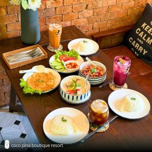 a table with plates of food and drinks on it at Coco Pina in Prachuap Khiri Khan