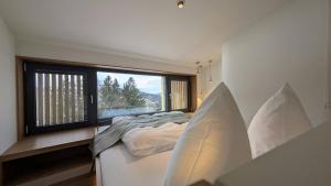 a bedroom with a bed and a large window at Edlgütl - Hideaway in Breitenberg
