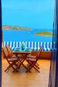 a table and chairs with a view of the ocean at Punta Est - Mono TRAMONTANA Soppalco & Sea View in Capo Coda Cavallo +6 photos