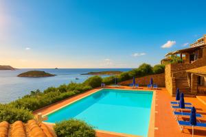 a swimming pool with a view of the water at Punta Est - Mono TRAMONTANA Soppalco & Sea View in Capo Coda Cavallo