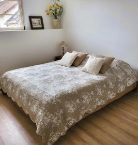 a bedroom with a large bed with a white comforter at L'Etalon, maison dans corps de ferme in Chailly-sur-Armançon