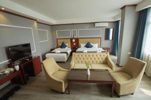 a hotel room with a couch and two beds at Eden De Vangvieng in Vang Vieng